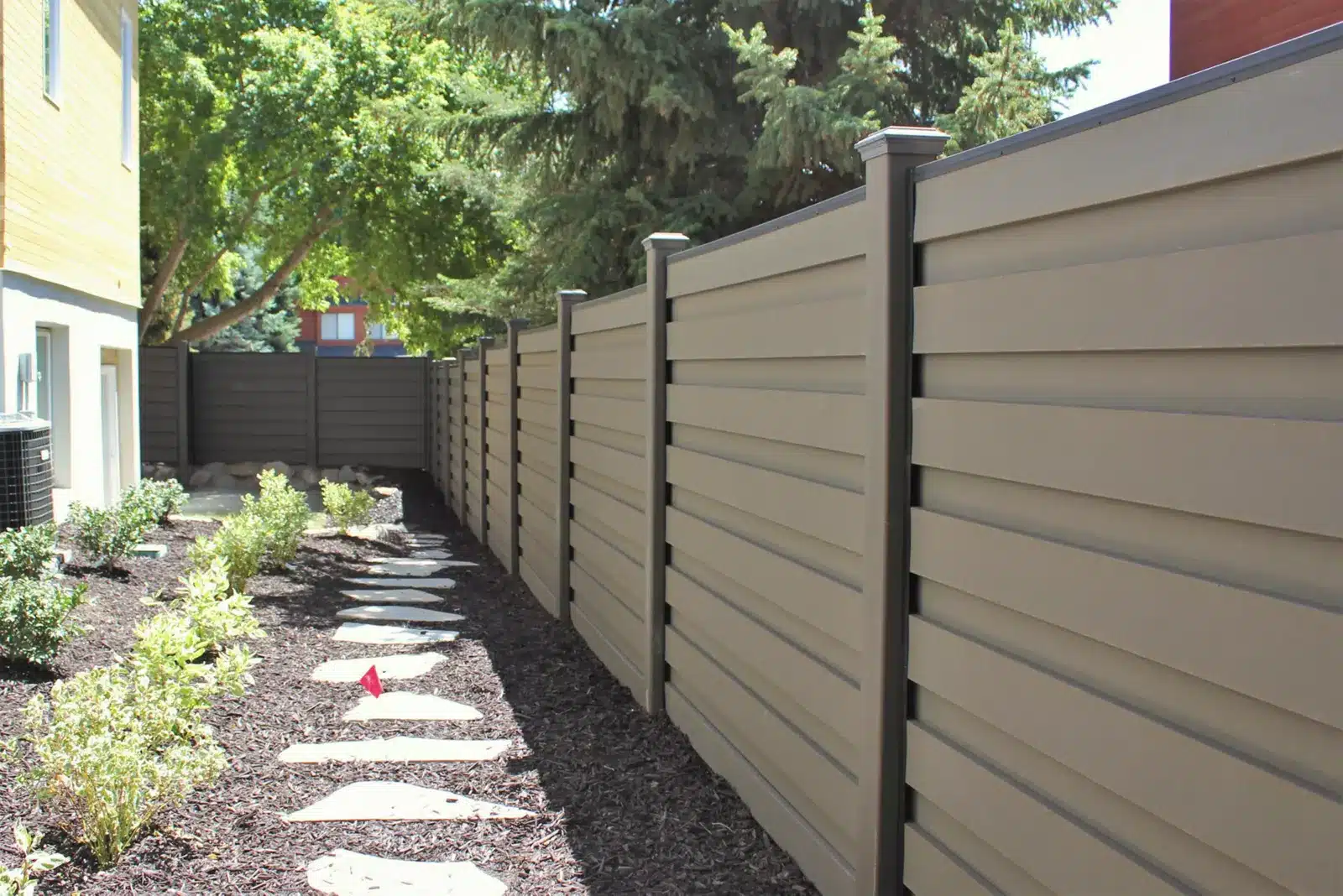 Modern Backyard Fencing Ideas 1 Backyard fence with a stone path in a garden.