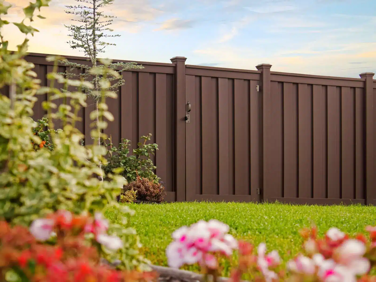 Modern Backyard Fencing Ideas 3 Beautiful brown Trex fence with a lawn and garden.
